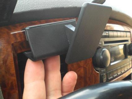 En hand håller i en svart monteringsdel för en Dodge Ram Pick Up 06-08.