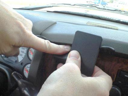 En hand installerar en del på instrumentpanelen i en Dodge Ram Pick Up 06-08.