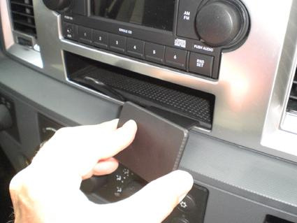 En hand som öppnar en förvaringslucka i en Dodge Ram Pick Up.