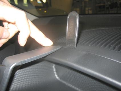 En hand pekar på en del av instrumentbrädan i en Citroen C1 06-14.