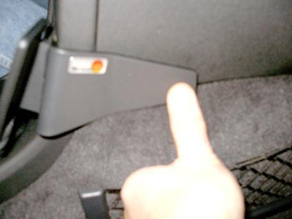 Ett vinklat plastdetalj med en hand som pekar på den.