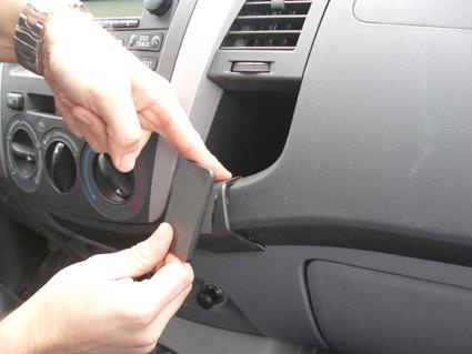 En person installerar en del i bilen Toyota HiLux 06-11.