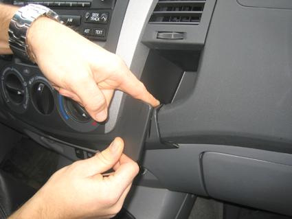 En hand visar hur man tar bort en panel i Toyota HiLux 06-11.