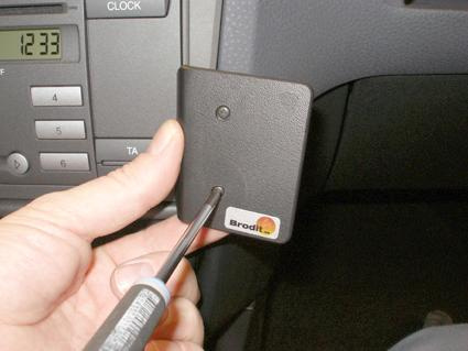 En hand håller i en montering med en skruvmejsel, troligen till en Ford Fiesta.