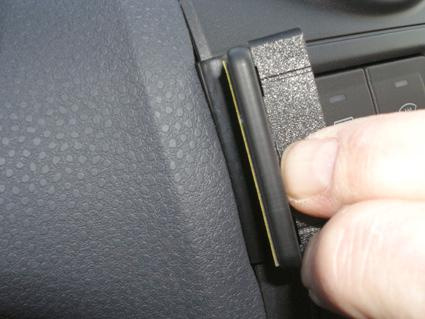 En hand som trycker på en del av instrumentbrädan i en Ford Fiesta.