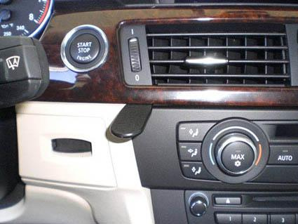 Interiör från BMW E90 med träpanel, knappar och luftutlopp.