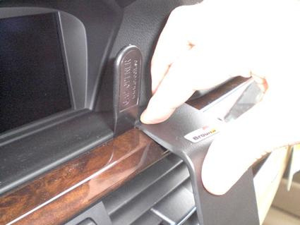 Hånd som fjerner del av interiørpanel i BMW E90.