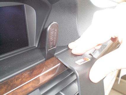 En hand justerar en träpanel på en BMW-inredning.