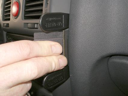 En hand håller i en vinklad plastdel för Hyundai Getz.