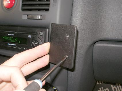 En hand som skruvar fast en del på insidan av en Hyundai Getz.