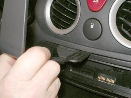 En hand sätter i en nyckel i instrumentpanelen på en Citroën C2/C3.