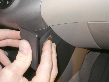 En hand trycker på en knapp på en bils instrumentpanel.