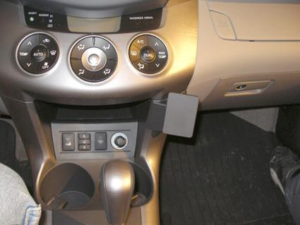 Insidan av en bil med kontrollpanel och växelspak.