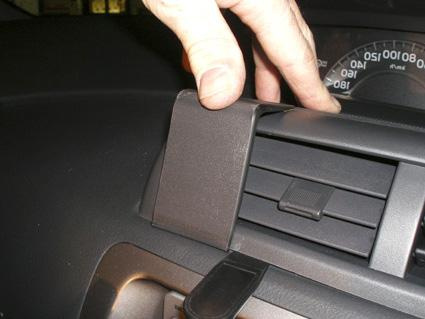 Del av bilinteriör med handen som justerar ventilationsgallret.