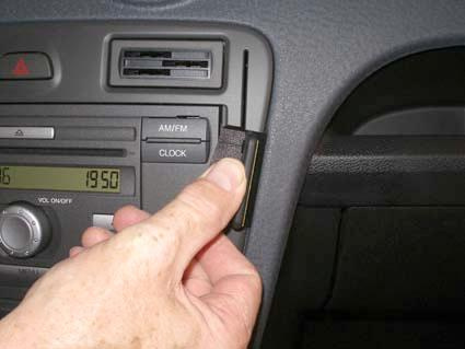 En hand justerar en del av bilens ljudsystem.