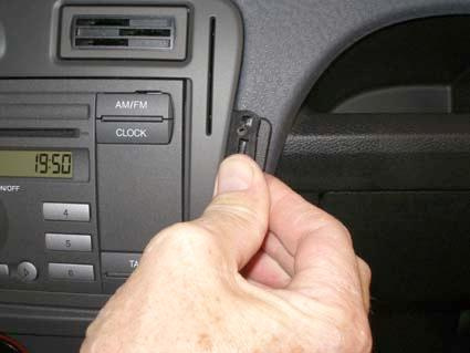 En hand håller en del av bilens instrumentpanel för Ford Fusion 06-12.