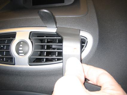 En hand som justerar luftintaget i en Renault Clio.