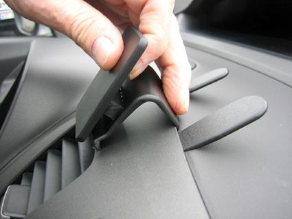 En hand som justerar en del av instrumentpanelen i en Honda Civic Hybrid.