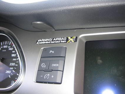 Instrumentpanel med varningsmärke för airbag och knappar.