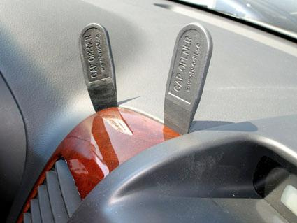 Två svarta plastverktyg för att öppna luckor i bilen.