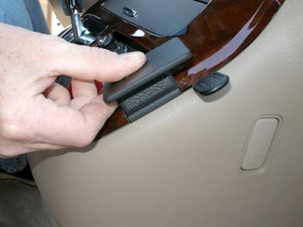 En hand placerar en del på interiören av Kia Carnival 06-11.