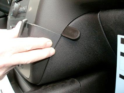 En hand visar en del av interiören i en Chevrolet Avalanche, med fokus på ett spår.