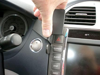 En bils instrumentbräda med kontroller för klimatanläggning och audio.