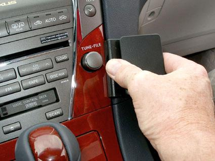 En hand justerar en enhet på en bilinteriör.