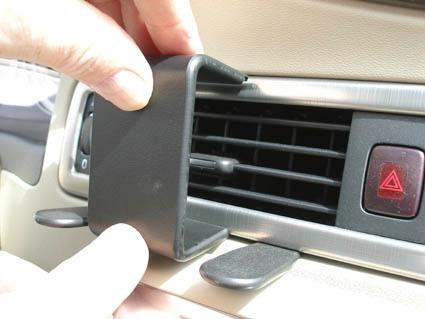 En hand installerar en luftventilationsdel i en Volvo.