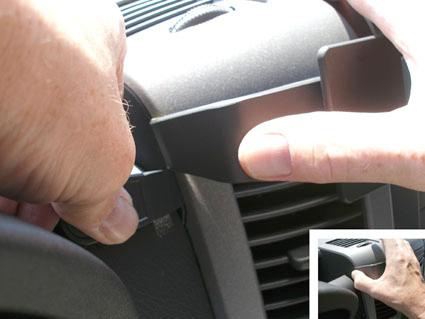 Det visas en hand som justerar en del av en bilinteriör.