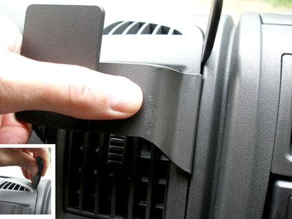 En hand som justerar en del vid bilens luftutlopp.