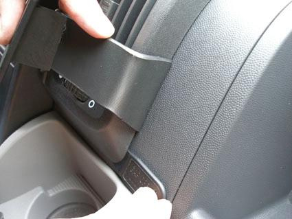 En hand håller en svart plastdel vid instrumentpanelen i Fiat Ducato.