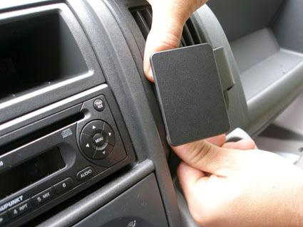 En hand installerar en del på dashboarden i en Fiat Ducato.