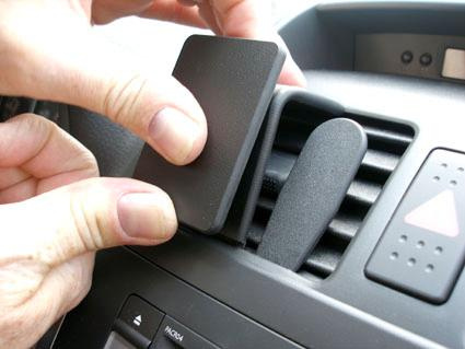 En person installerar en del på bilens luftventil.