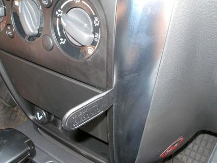 Vinklad konsol med knappar för luftkonditionering och förvaringsfack.