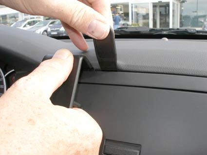 En hand justerar en del av bilens interiör, troligen på en Chevrolet Epica.