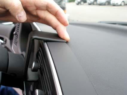 En hand justerar en del av instrumentbrädan i en Saab 9-3.