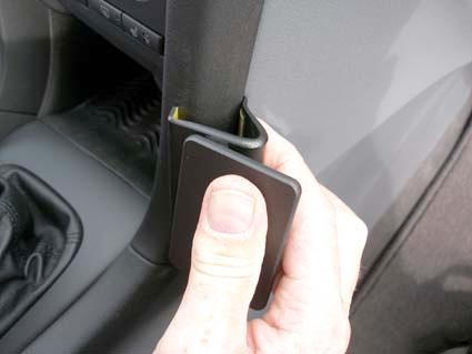 En hand håller en vinklad del i en bil, troligen relaterad till Saab 9-3.