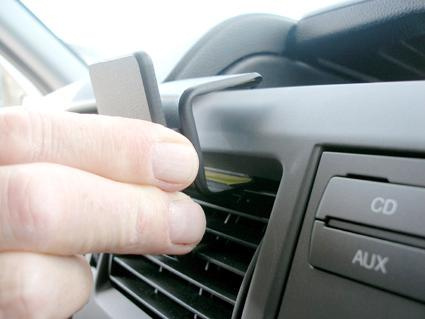 En hand håller i en del som ska fästas på en luftutlopp.