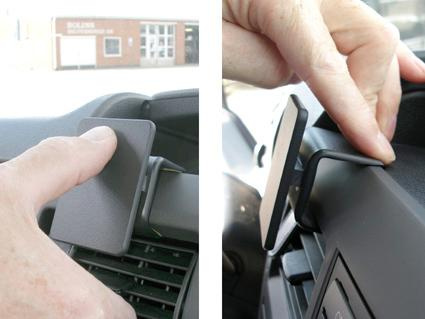 En hand fäster en hållare på instrumentbrädan i en Ford Transit.