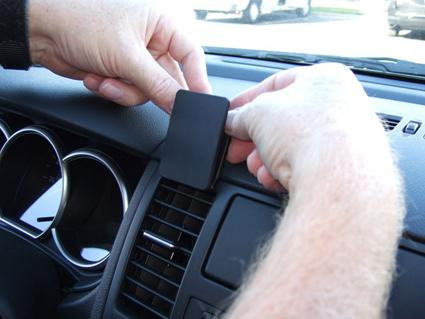 Montering av en enhet på ventilationsgallret i en bil.