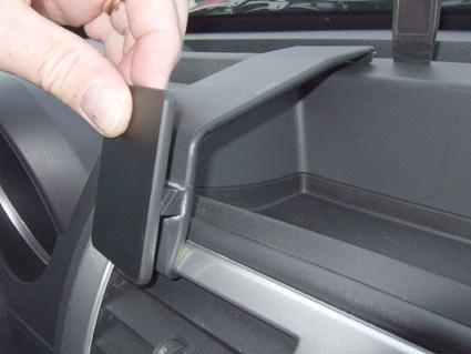 En hand som öppnar ett fack i instrumentbrädan på en Dodge Nitro 07-12.