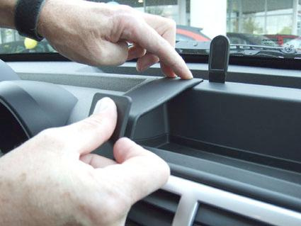 En hand monterar en del på instrumentbrädan i en Dodge Nitro 07-12.