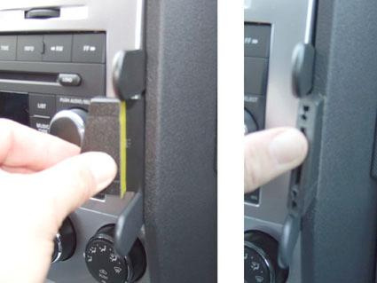 En hand som justerar en vinklad del på en bilradio, troligen för Dodge Nitro 07-12.