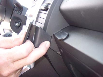 En hand fäster en del på instrumentbrädan i en Mazda 5 05-10.