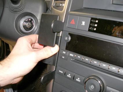 En hand som justerar en del av bilens instrumentbräda.