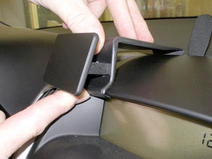 Visar en hand som installerar ett biltillbehör på instrumentpanelen.