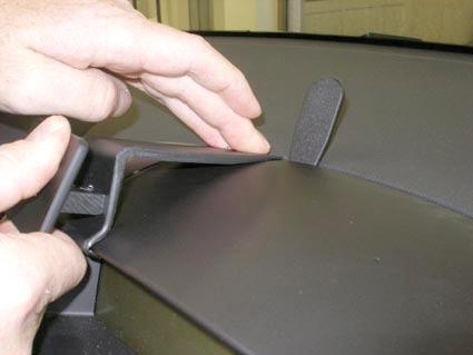 En person fäster en del på bilens instrumentbräda, troligen för Kia Ceed 07-09.