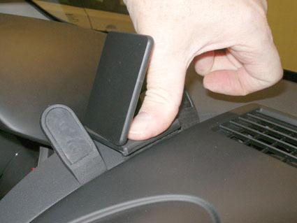 En hand justerar ett fäste på instrumentbrädan i en Nissan Qashqai.