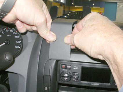Händer som tar bort en panel från instrumentbrädan i en Fiat Scudo.
